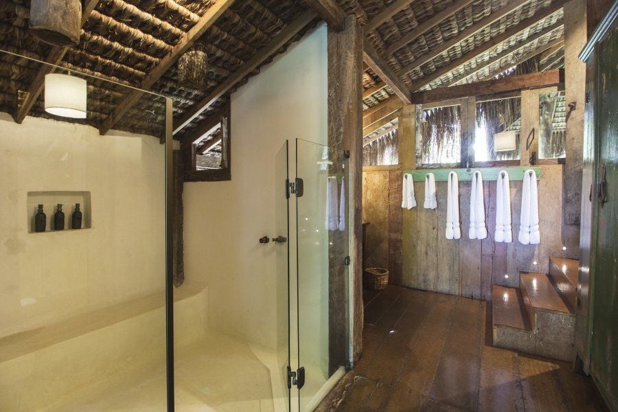 Rustic treehouse-style luxury suite at UXUA Casa Hotel with wooden interiors, lush Brazilian rainforest backdrop, and elegant minimalist design aesthetic