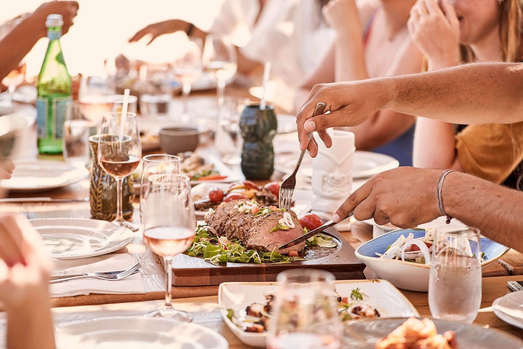 Luxurious white-washed Greek beachfront hotel with minimalist design, overlooking turquoise Aegean waters and pristine sandy coastline at sunset