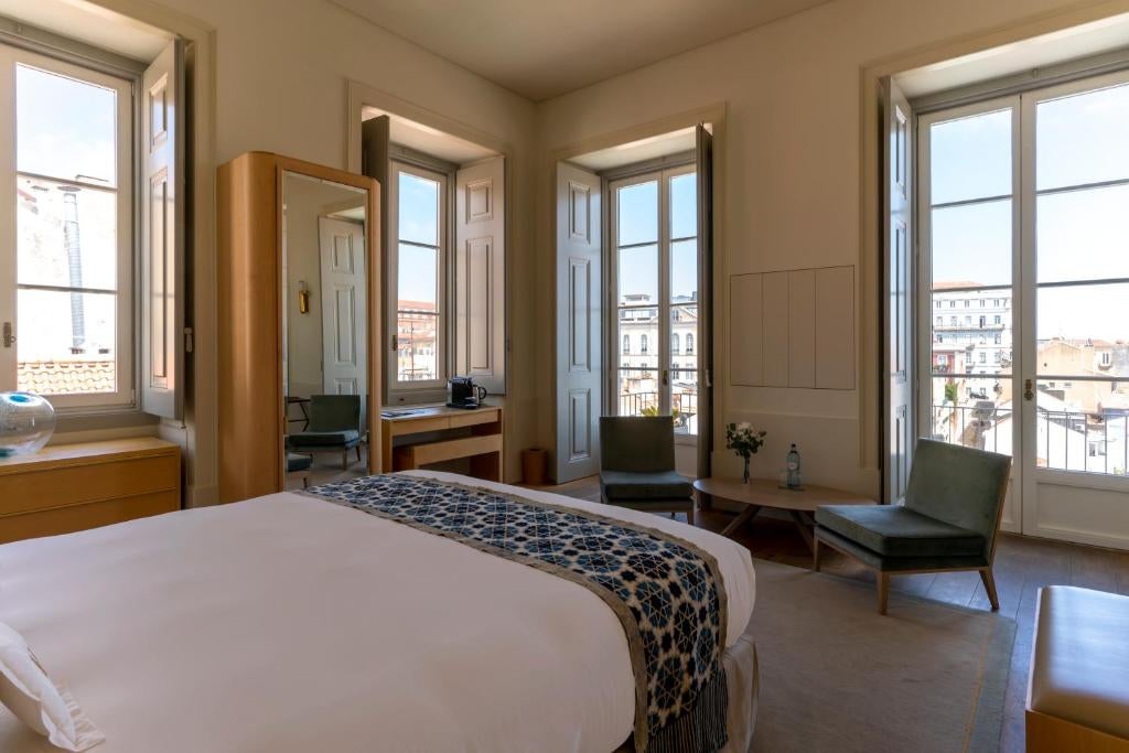 Elegant 18th-century palace hotel with classical white façade, ornate balconies, and traditional Portuguese blue and white tiles in Lisbon