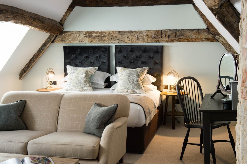 Spacious feature room at Kings Head Hotel with plush king-size bed, elegant wooden furnishings, and soft ambient lighting highlighting British countryside charm