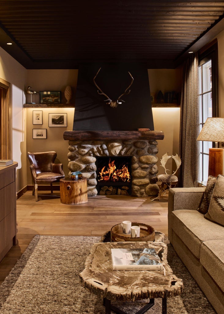 Luxurious alpine-style lodge with wood paneling, warm lighting, and elegant rustic decor at scenic mountain hotel nestled in French landscape