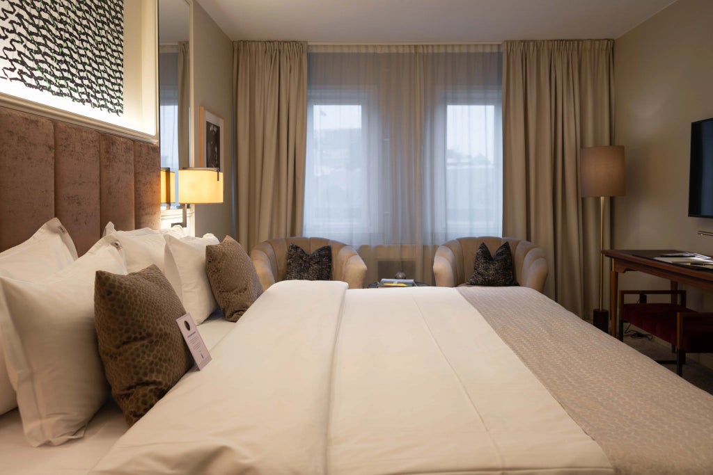 Luxurious modern hotel room at Bank Hotel with pristine white linens, marble bathroom, contemporary design, and elegant neutral color palette in Sweden