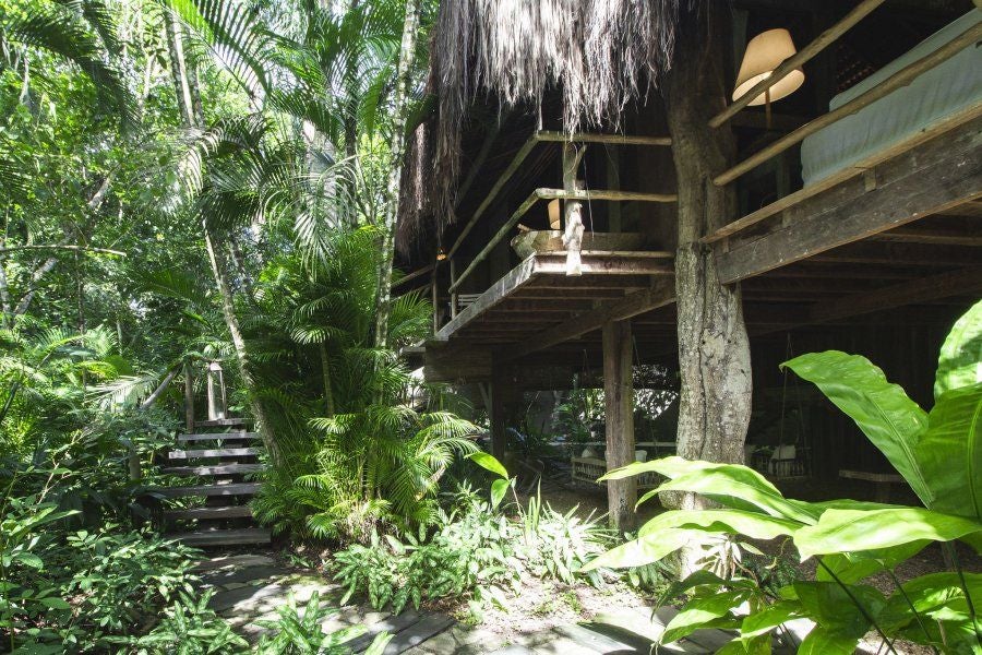 Luxurious treehouse suite at UXUA Casa Hotel and Spa, blending rustic wood, lush greenery, and modern design in a tropical Brazilian setting