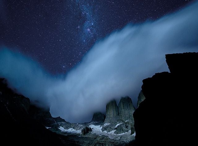 Luxurious lodge nestled in Torres del Paine National Park, Chile, with rugged mountain peaks, native forests, and pristine wilderness landscape