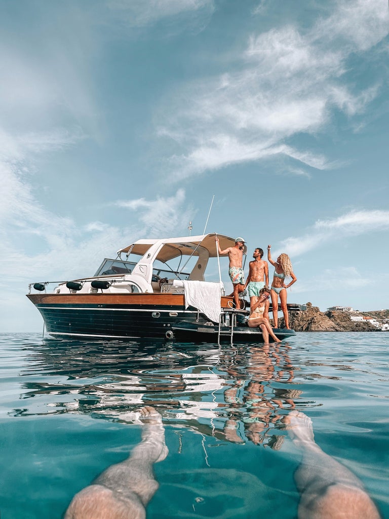 Luxurious white yacht anchored in crystal-clear turquoise waters near Menorca's pristine coastline under bright Mediterranean sun