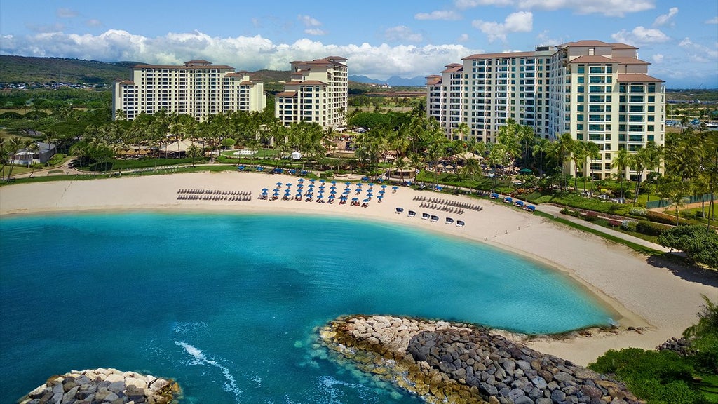 Luxurious beachfront resort with palm trees, sparkling pool, and modern Hawaiian-style architecture at tropical scenset resort in Hawaii