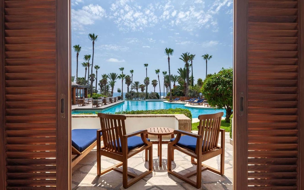 Elegant terrace sea view room at luxury Cyprus hotel with modern decor, plush white bedding, and panoramic azure Mediterranean coastline vista