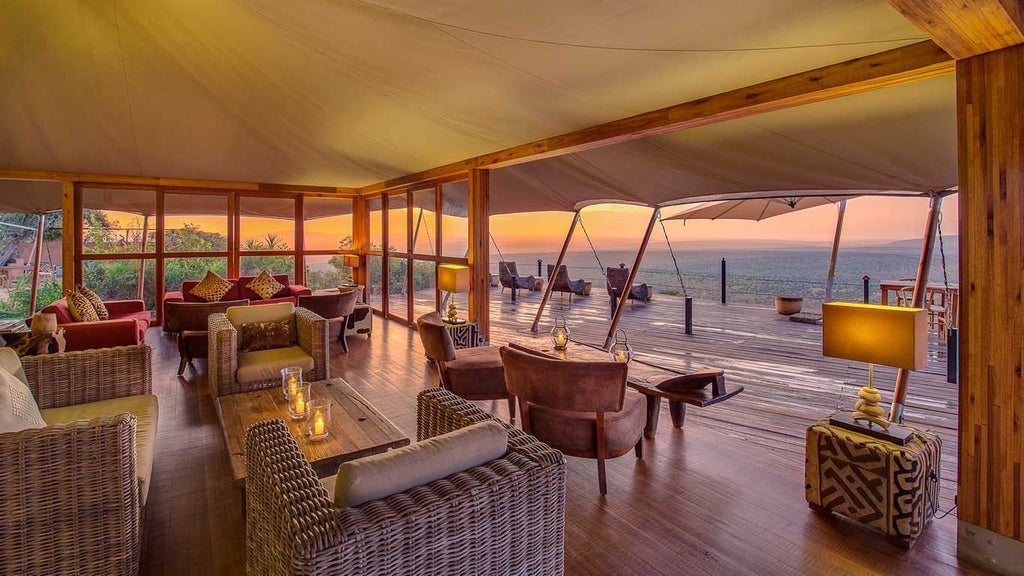 Luxurious safari tents overlooking dramatic Kenyan wilderness with sweeping savanna landscape and distant mountain silhouettes at golden hour