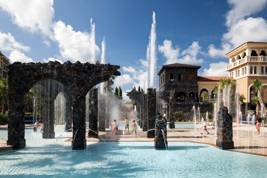 Luxurious Four Seasons Orlando resort with illuminated Mediterranean-style architecture reflects in calm pool waters at twilight hour