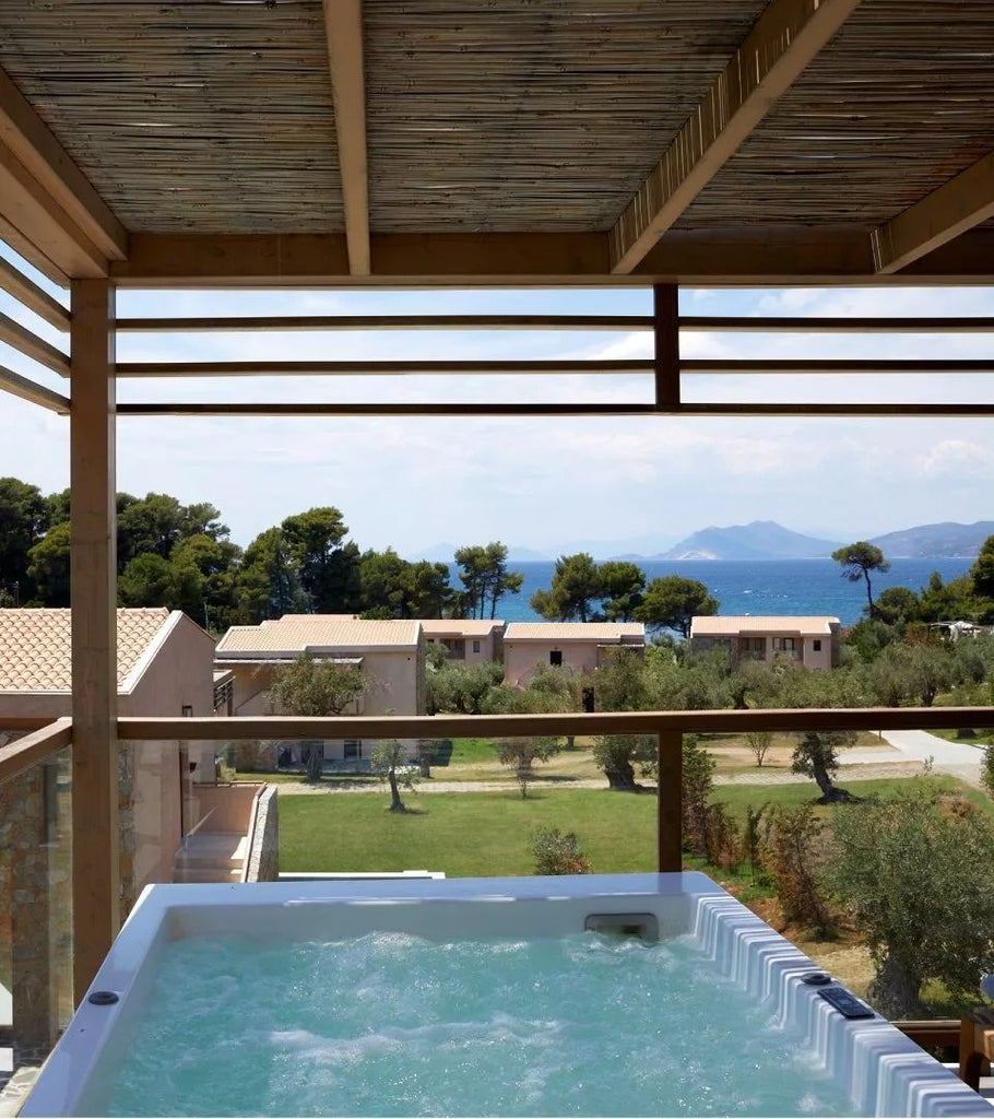 Luxurious junior suite with private hot tub overlooking the azure Aegean Sea, featuring modern design and elegant white decor at ELIVI Skiathos Hotel, Greece