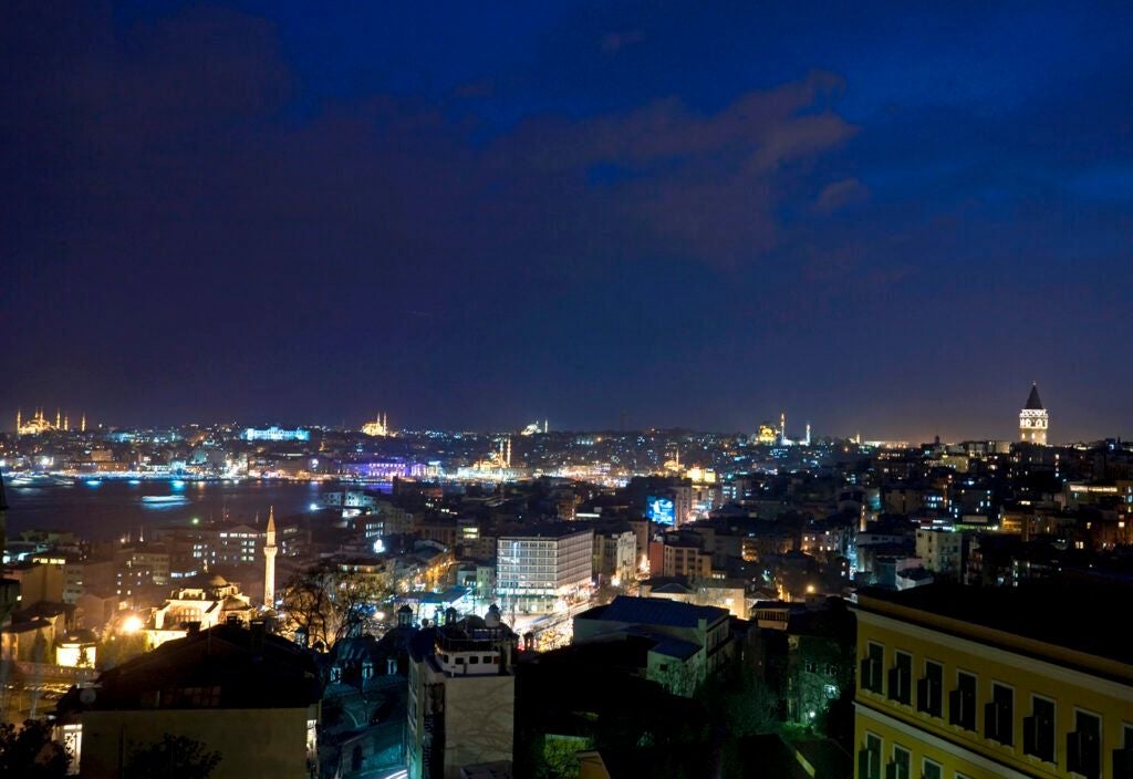 Elegant boutique hotel in Istanbul with modern gray facade, sleek architectural lines, floor-to-ceiling windows, and contemporary urban design aesthetic