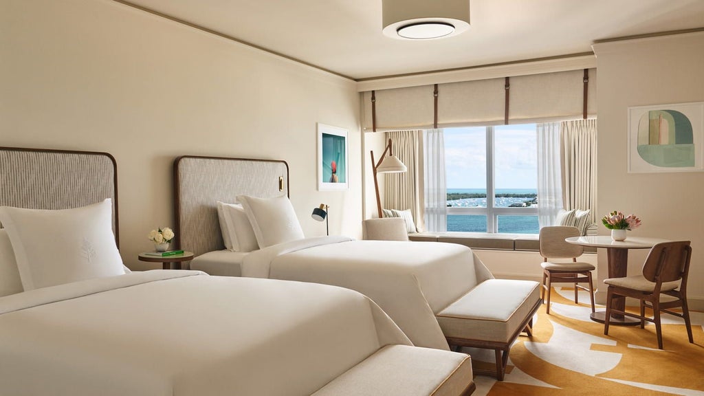 Luxurious Four Seasons Hotel Miami Premier Bayfront Room with floor-to-ceiling windows, modern decor, and stunning panoramic water views of Biscayne Bay