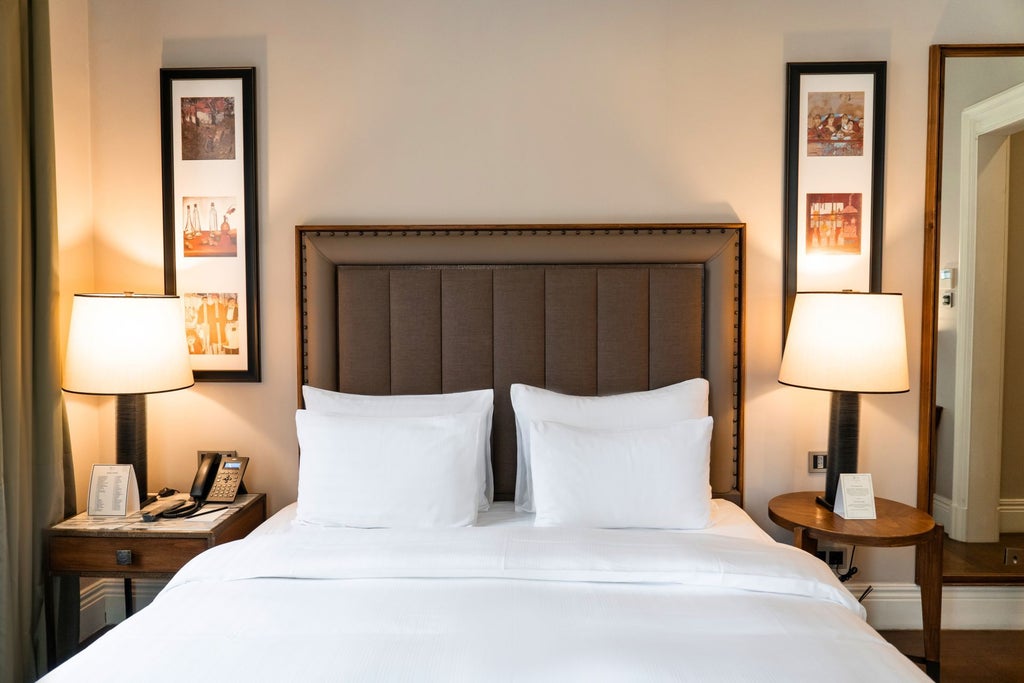 Elegant superior king room at The Bank Hotel Istanbul, featuring plush bedding, modern design, and warm wooden furnishings with soft ambient lighting