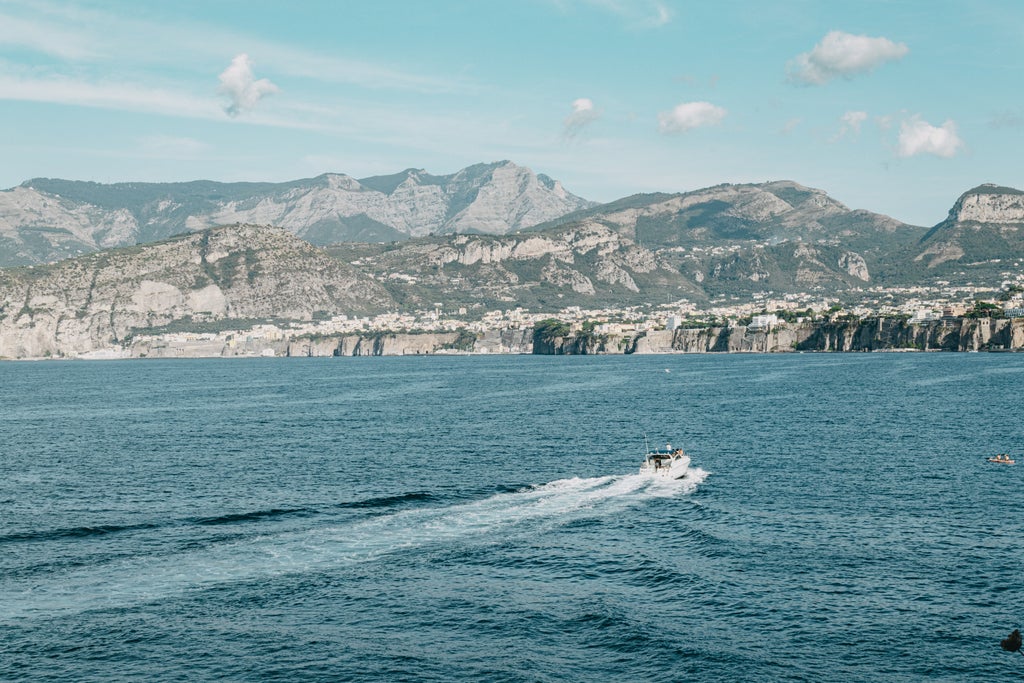 Sun-drenched cliffside villas cascade down Amalfi Coast's dramatic limestone cliffs, with luxury yachts dotting the sparkling Mediterranean waters