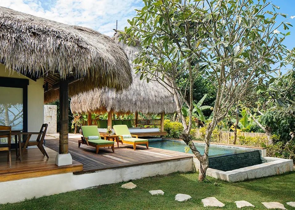 Luxurious wooden villa overlooking lush tropical landscape, infinity pool blending with oceanview at NIHI Sumba resort in Indonesia