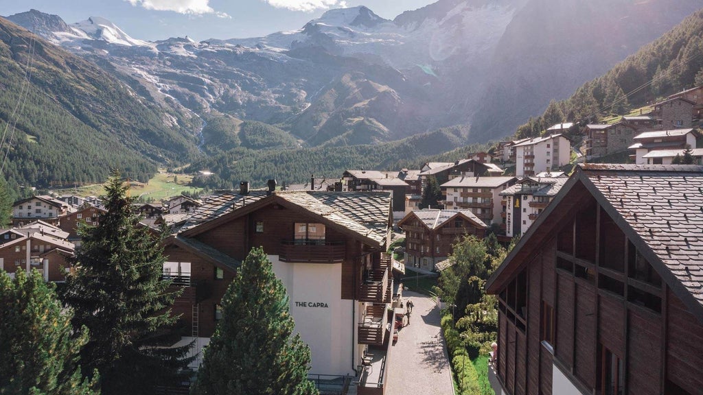 Luxurious alpine chalet hotel nestled in Swiss mountains, featuring wooden balconies, snow-capped peaks, and elegant rustic design at The Scenset Capra