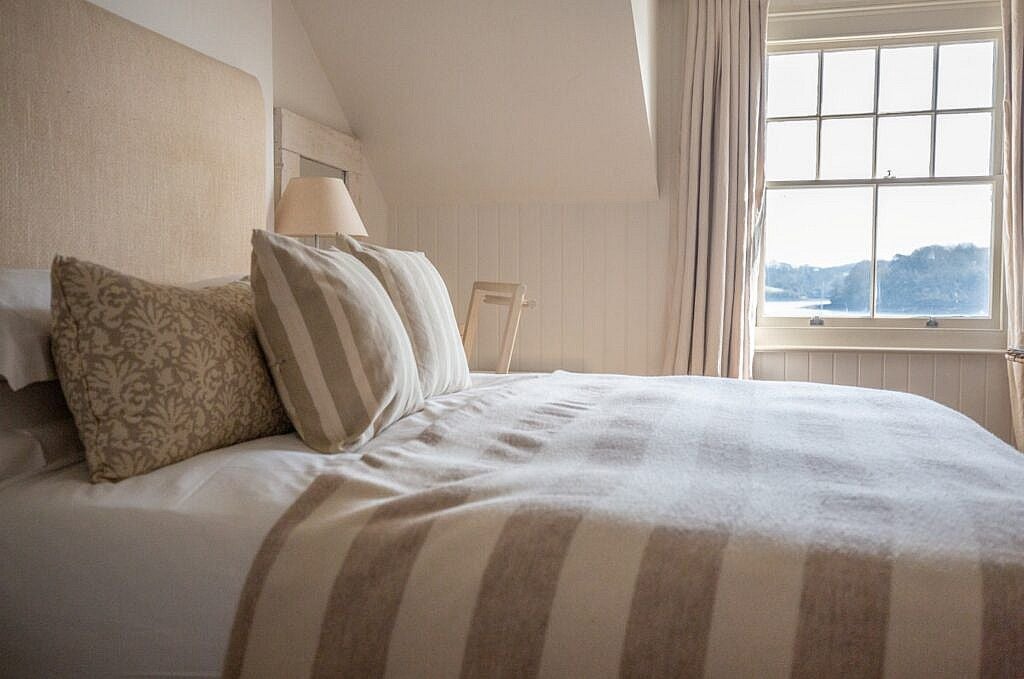 Luxurious superior seaview room at coastal UK hotel, featuring elegant decor, crisp white linens, and panoramic ocean vista through large windows