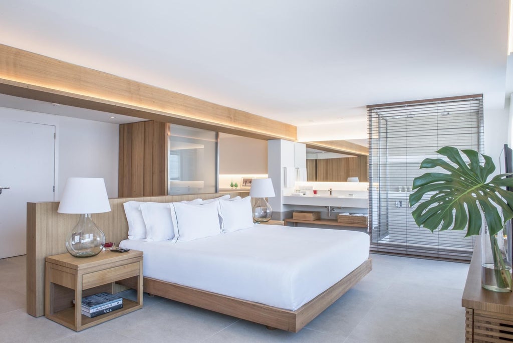 Spacious luxury suite with panoramic ocean view, modern Brazilian design, sleek king bed, floor-to-ceiling windows, and minimalist tropical elegance