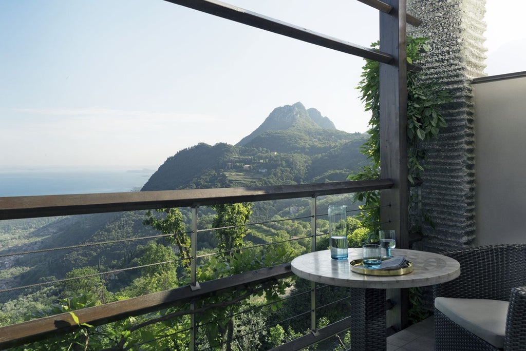 Luxurious hillside resort overlooking Lake Garda, featuring an infinity pool merging with the blue lake waters and mountain vista