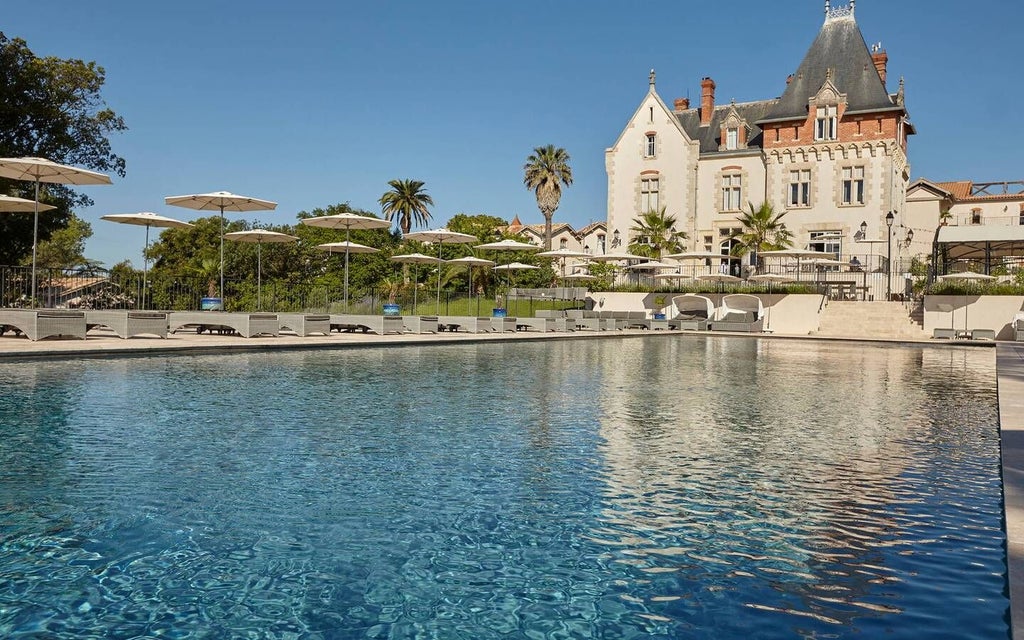 Elegant French château nestled among vineyards, featuring stone architecture, manicured gardens, and rolling Languedoc countryside at golden hour