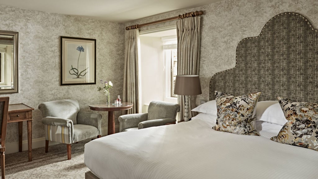 Elegant castle-style hotel room with rich wooden furnishings, antique decor, and plush bedding in traditional British country estate style at Bovey Castle Hotel and Spa