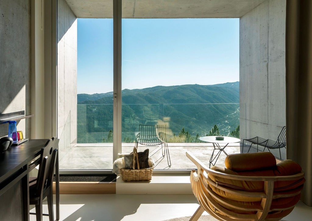 Elegant Portuguese mountain hotel room with panoramic windows, contemporary minimalist design, and breathtaking alpine landscape view at scenset.