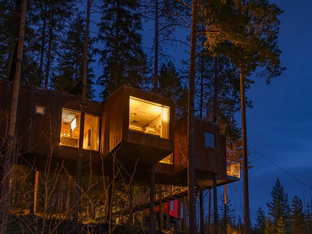 Minimalist mirrored treehouse suspended among pine trees in Swedish forest, reflecting surrounding landscape with sleek, futuristic architectural design