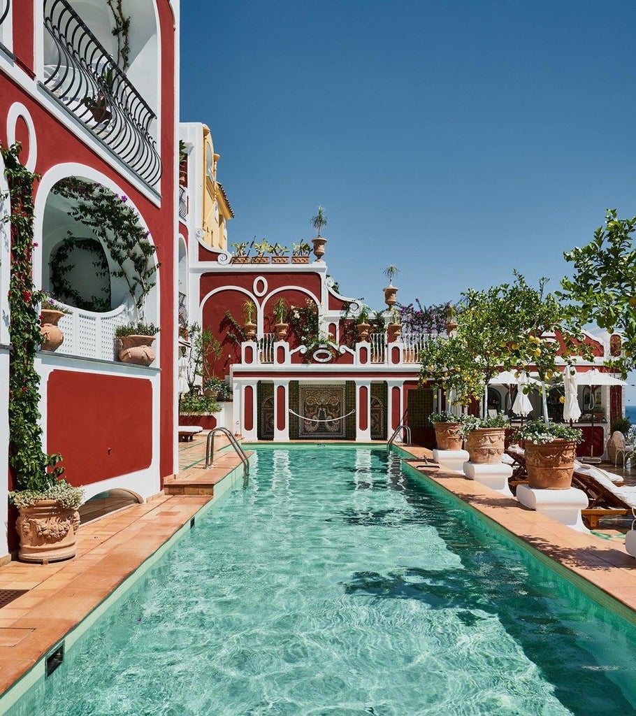 Luxurious cliffside hotel in Positano with white terraces cascading down the hillside, overlooking the turquoise Mediterranean Sea