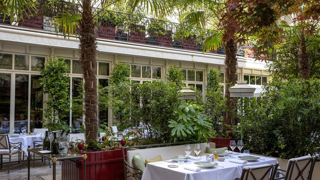 Elegant Parisian hotel exterior with Eiffel Tower view, luxurious neoclassical architecture, grand entrance, and refined architectural details at dusk