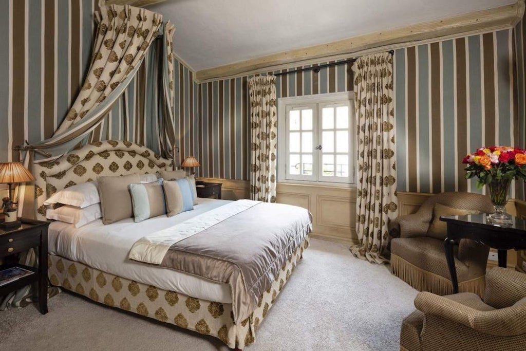 Luxurious hotel room with plush white bedding, elegant wooden furnishings, soft ambient lighting, and French-inspired decor at Hotel Le Saint Paul