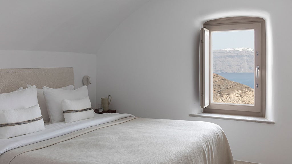 Luxurious two-bedroom suite with panoramic Aegean views, white minimalist decor, private plunge pool, and elegant Santorini island architectural design