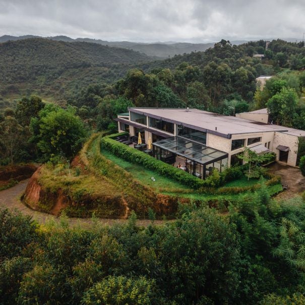 Modern luxurious bungalow with floor-to-ceiling windows nestled in Madagascar rainforest, featuring private wraparound wooden deck