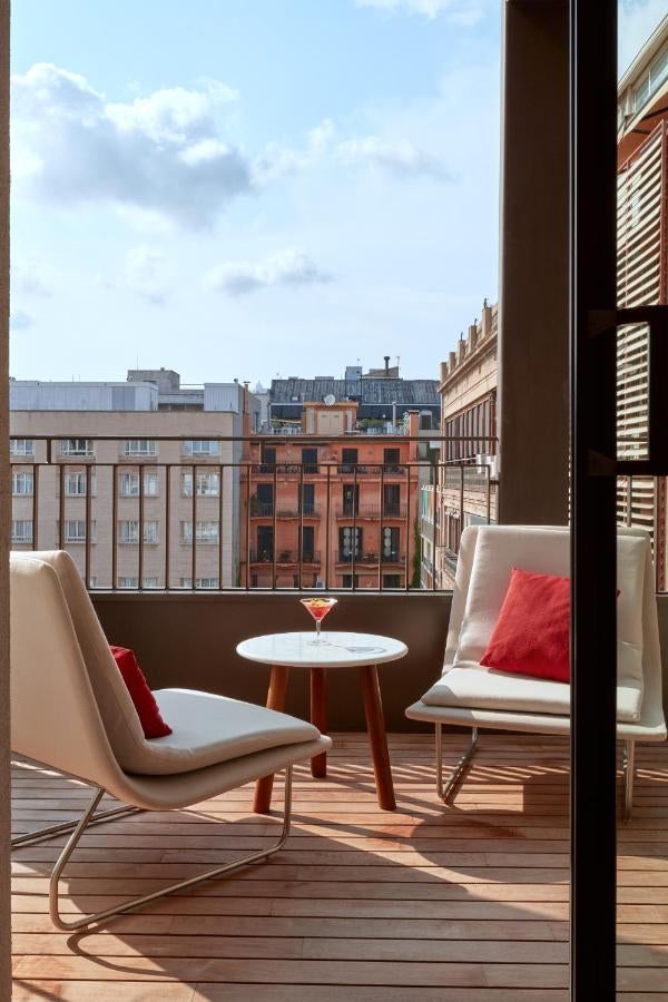 Modern luxury hotel facade with Art Nouveau elements, brass accents, and floor-to-ceiling windows set in Barcelona's historic district