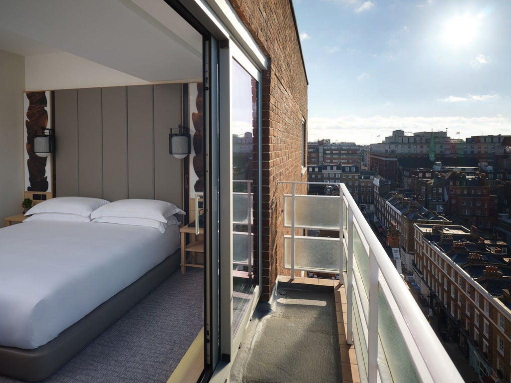 Elegant Nobu Hotel London Portman Square Junior Suite with modern minimalist design, soft neutral palette, and plush king bed overlooking city skyline