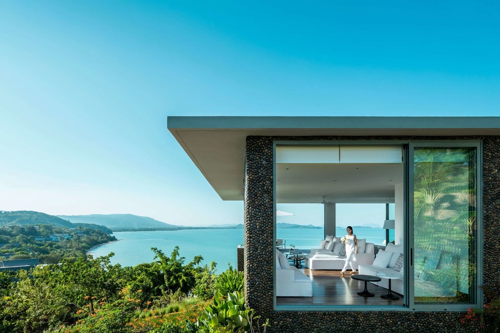 Luxurious scenic hotel overlooking turquoise Phang Nga Bay with modern architectural design, minimalist white exterior, and dramatic limestone cliffs in Thailand