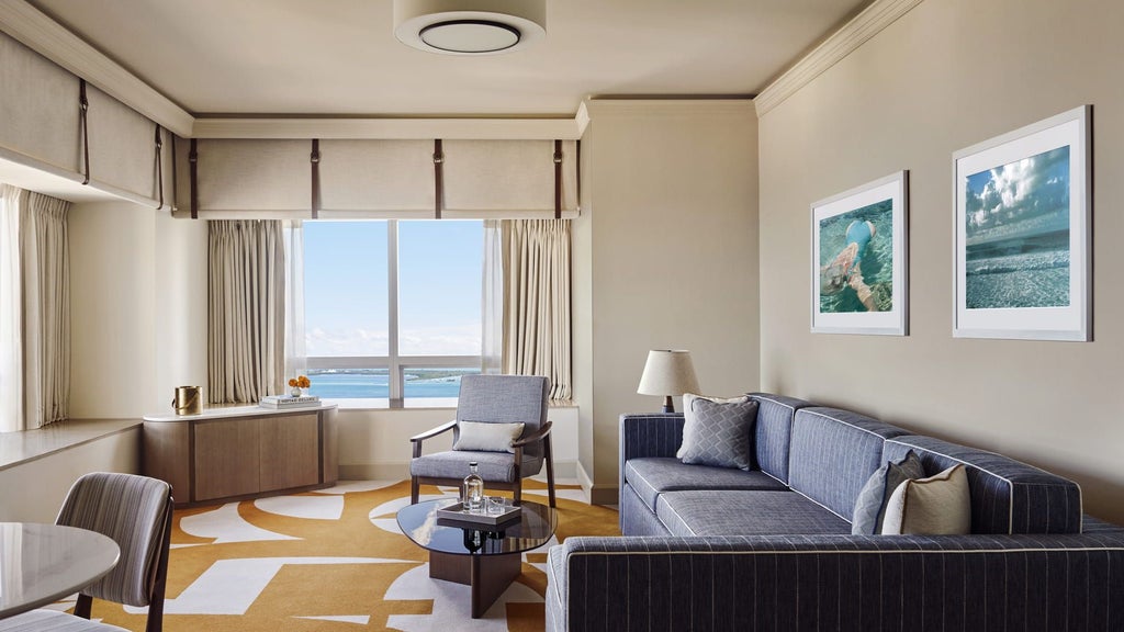 Spacious luxury corner suite with panoramic Miami skyline and Biscayne Bay views, featuring modern decor, floor-to-ceiling windows, and elegant contemporary furnishings