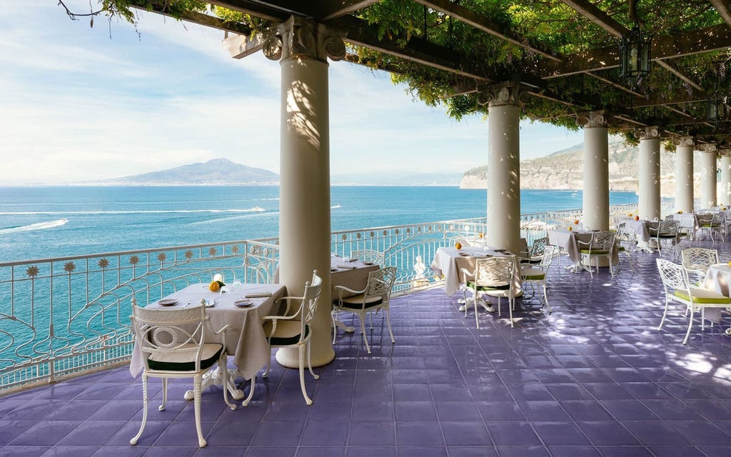 Luxurious cliffside hotel overlooking azure Mediterranean waters, with elegant white architecture and classical Italian Coastline design in Sorrento