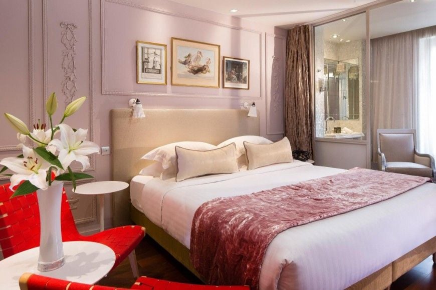 Elegant Parisian hotel room with plush rose-colored decor, soft lighting, and romantic French-inspired design at boutique Hotel & Spa La Belle Juliette