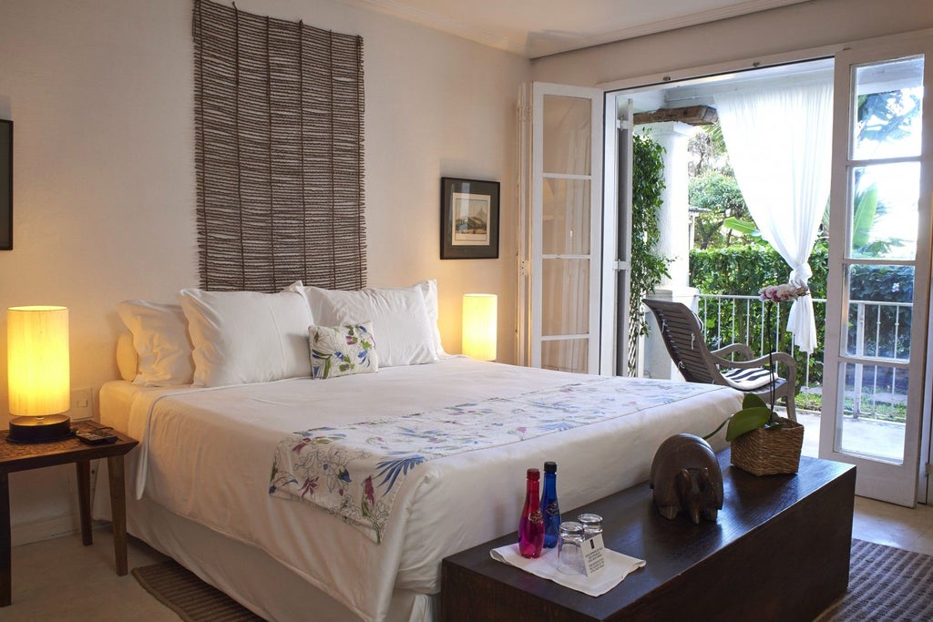 Elegant deluxe hotel room with private balcony overlooking historic Santa Teresa neighborhood, featuring refined Brazilian design and luxurious serenity