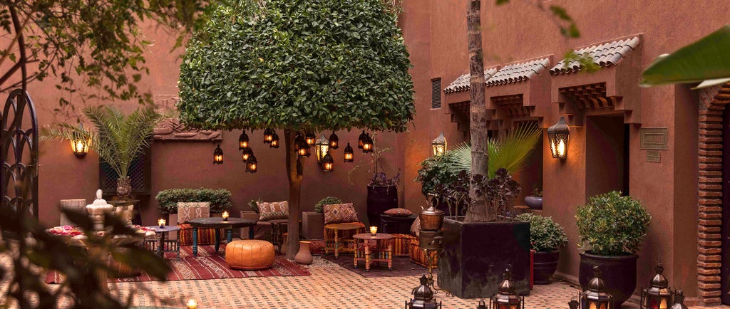 Luxurious stone Moroccan Kasbah hotel nestled in Atlas Mountains, featuring traditional architecture and lush gardens with pool