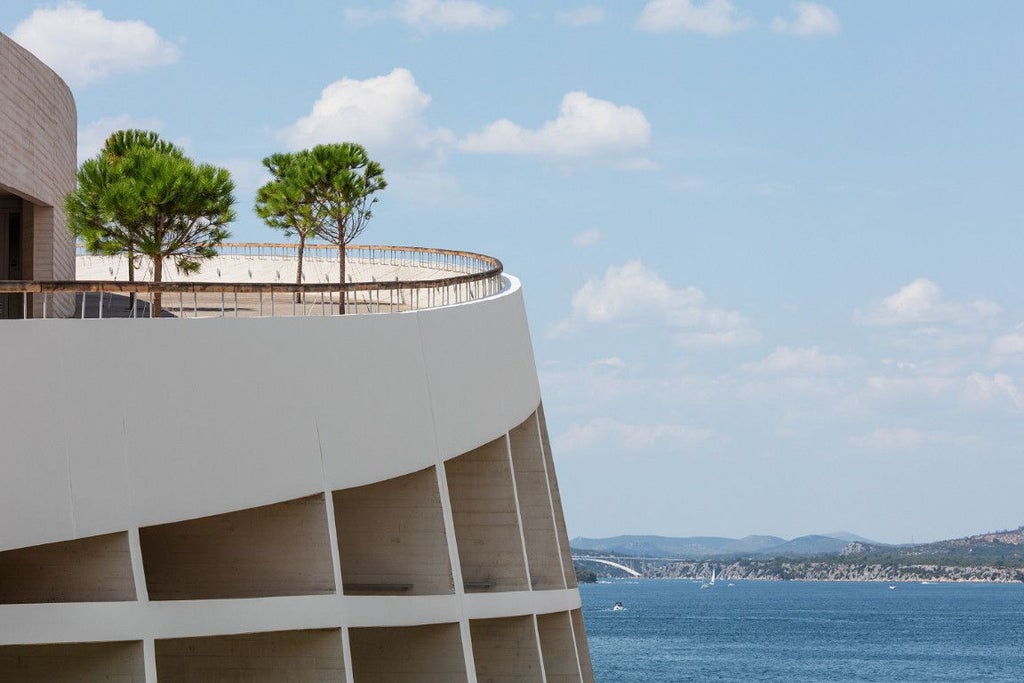 Luxurious waterfront hotel with modern architecture overlooking azure Adriatic Sea, featuring sleek design and panoramic coastal views of Šibenik, Croatia