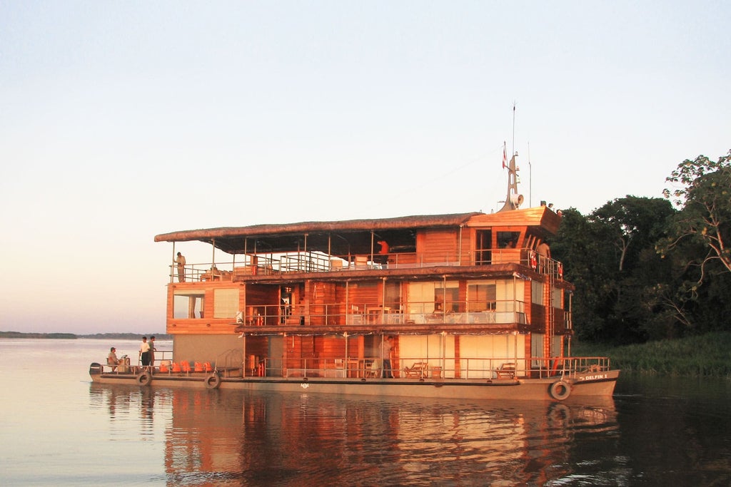 Luxurious wooden riverboat with panoramic windows glides through the Amazon, reflecting in calm waters against lush rainforest backdrop