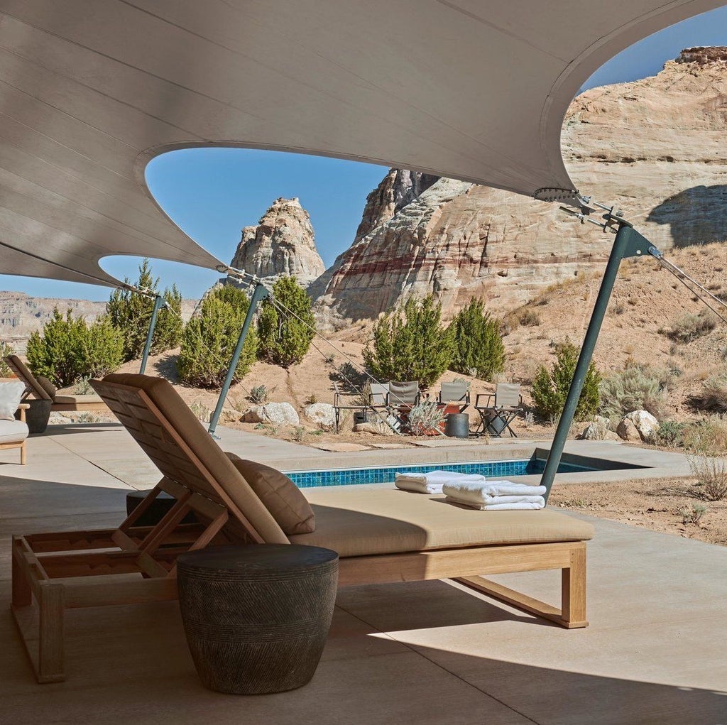 Luxury desert resort Amangiri nestled into sandstone cliffs, featuring minimalist concrete architecture and infinity pool at sunset