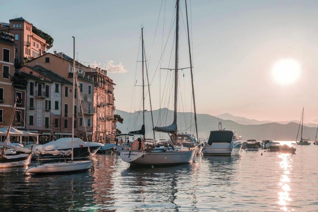 Vibrant Mediterranean harbor in Portofino with colorful pastel buildings, luxury yachts, and historic architecture along calm waters