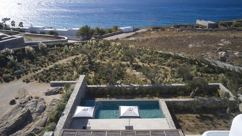 Luxury beachfront hotel in Mykonos with whitewashed buildings, infinity pool overlooking the Aegean Sea and traditional Greek architecture