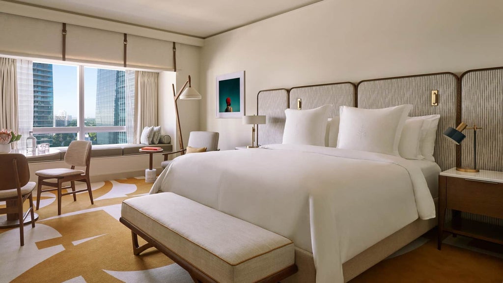 Luxurious Four Seasons hotel room in Miami with floor-to-ceiling windows, contemporary design, and sweeping cityscape views of downtown skyline