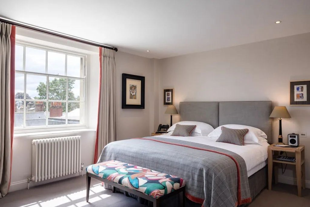 Luxurious deluxe hotel room at Old Bank Hotel, featuring elegant period furnishings, rich wooden floors, and soft neutral color palette with classic British design elements.