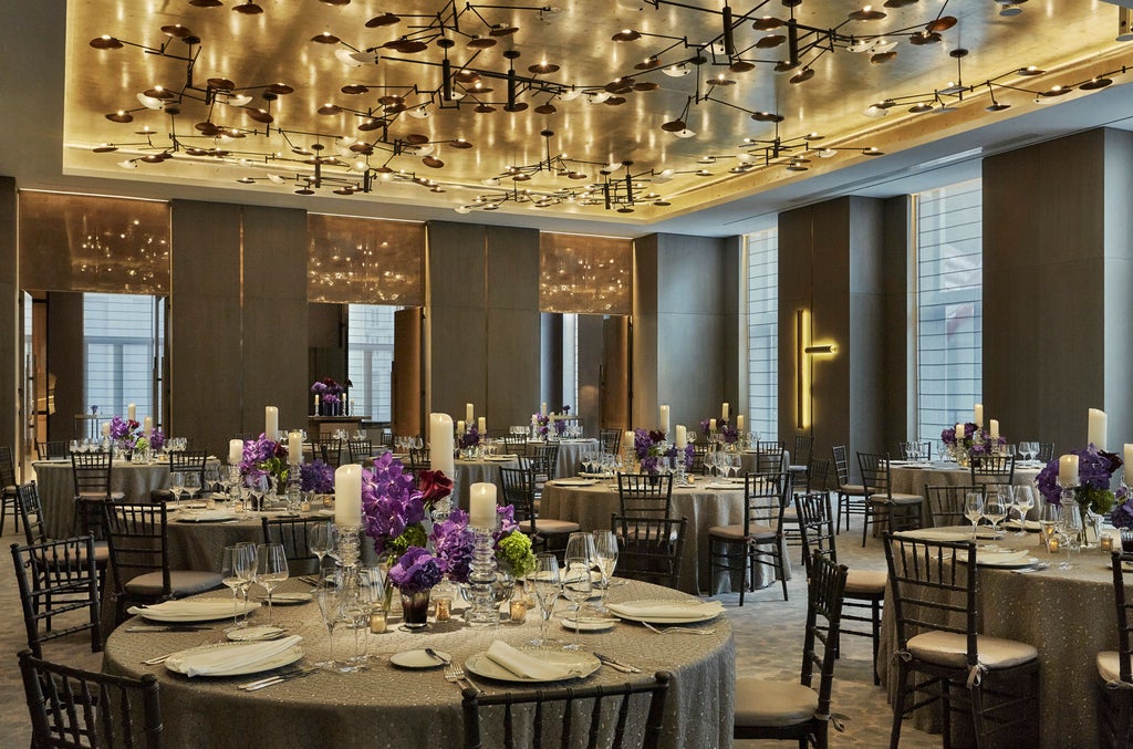 Grand marble lobby of Four Seasons NYC Downtown featuring dramatic spiral staircase, crystal chandeliers and plush modern seating area