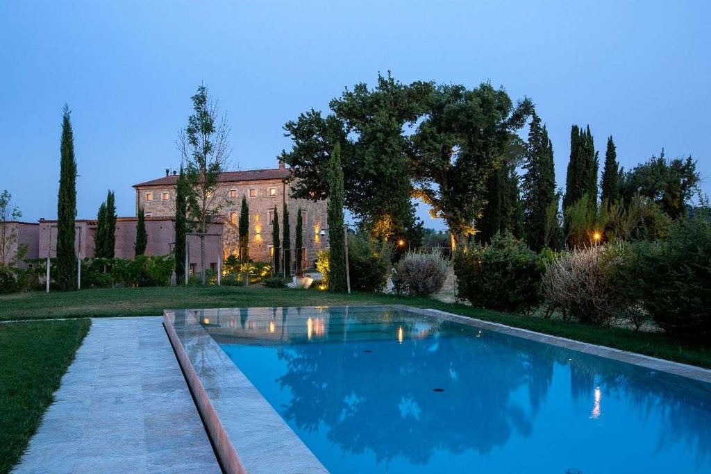 Elegant Mediterranean villa with stone facade, arched windows, and manicured gardens, nestled in Italian countryside at sunset