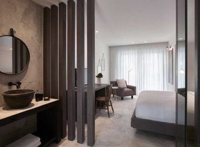 Sleek modern deluxe double room at Lango Design Hotel & Spa, featuring minimalist white decor, plush bedding, and elegant contemporary Greek design aesthetic